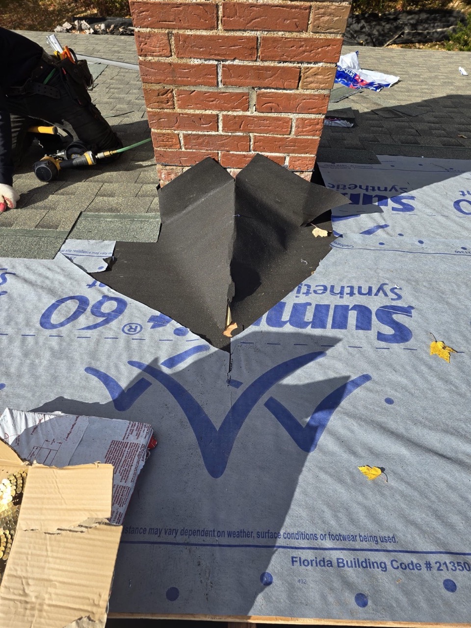 Close-up of ridge flashing and synthetic underlayment during a Genesis General Construction roof install