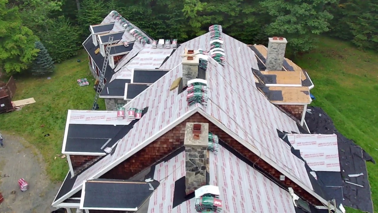 Aerial view of finished roofs on a row of homes set among trees