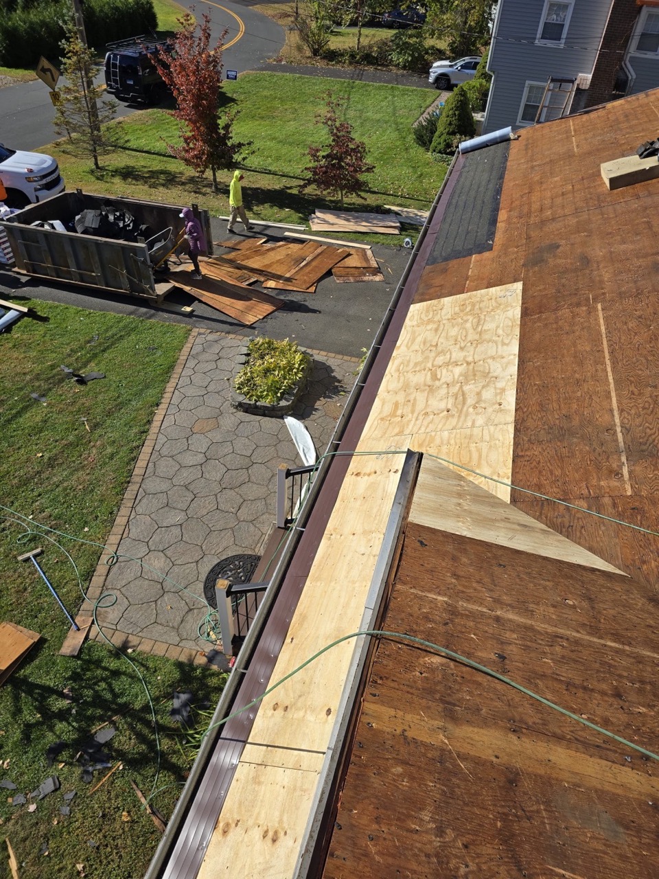 Aerial view of a roof tear-off with plywood decking exposed